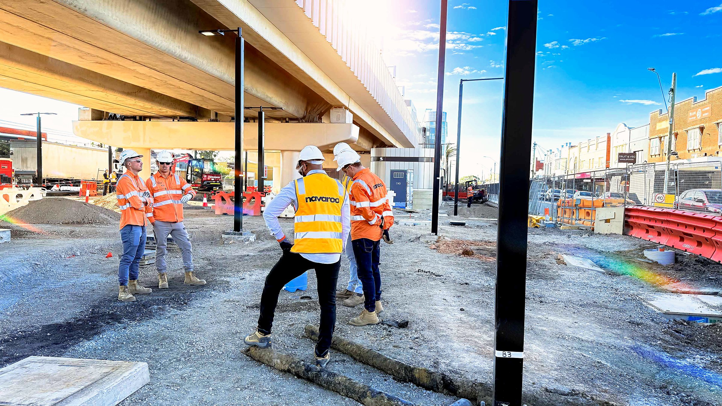 Navaroo crew working on external civil works beneath an elevated rail structure.