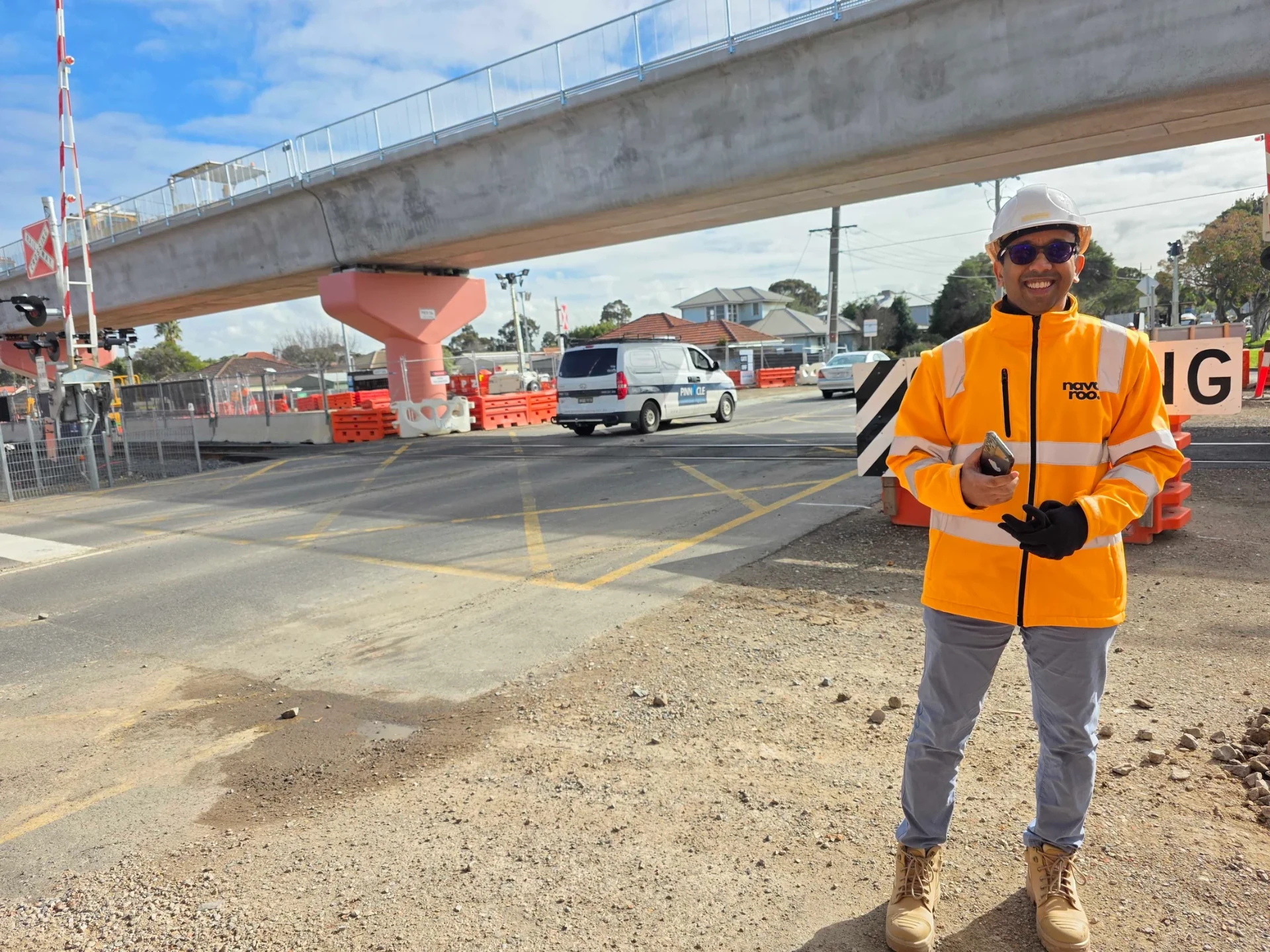 Navaroo team member in branded hi-vis and hard hat standing at a site access point.